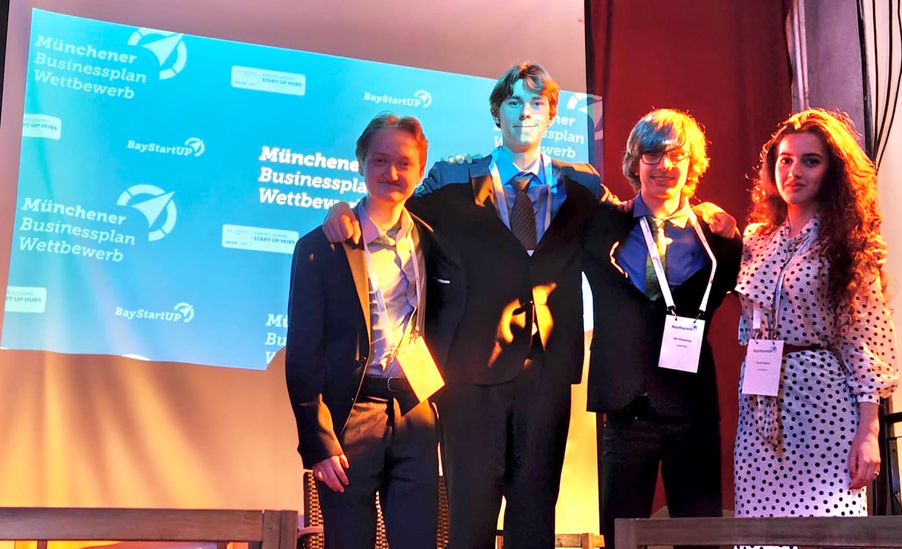 Four members of the CashXChain team on stage at the Munich Business Plan Competition, in front of a BayStartUP backdrop.